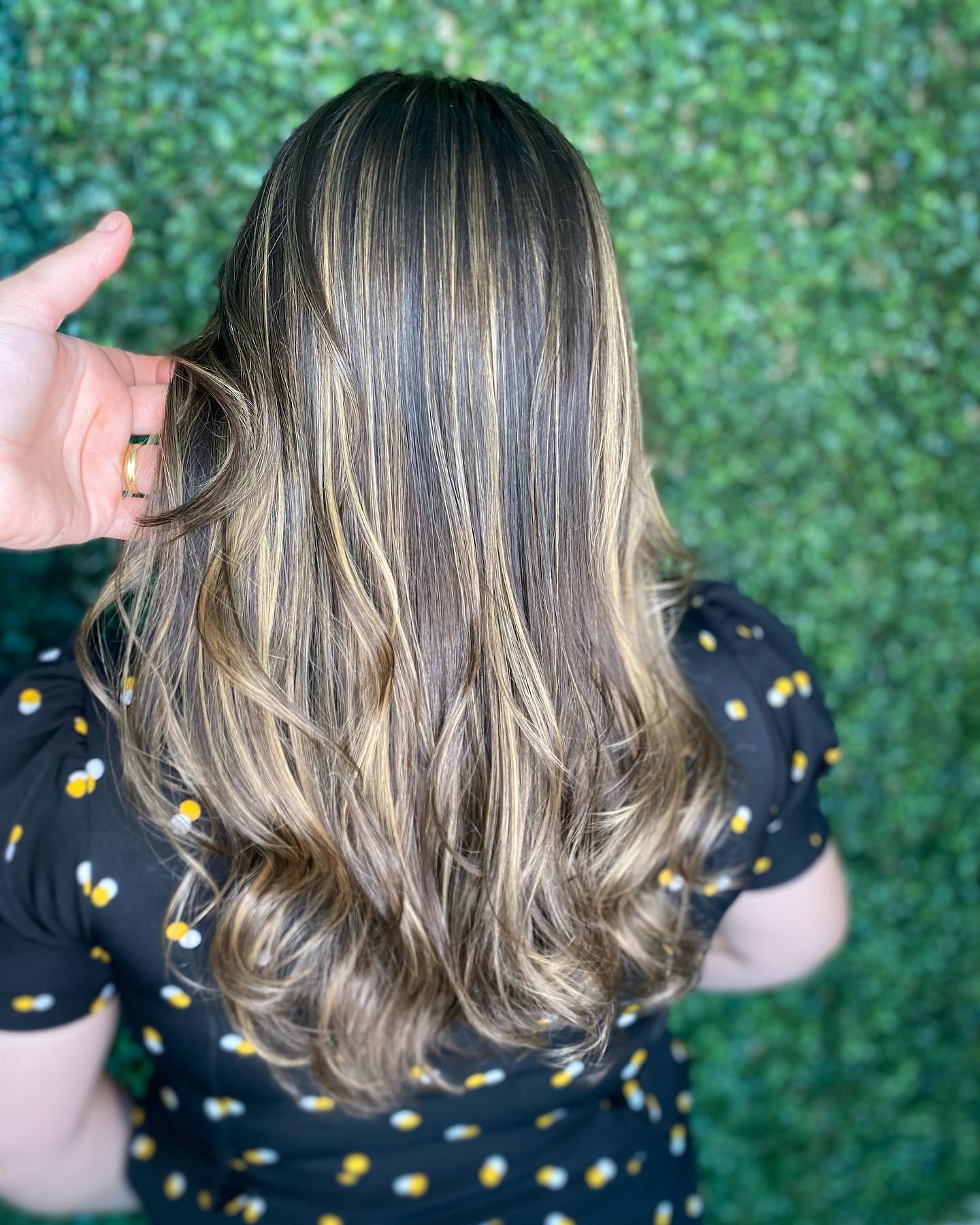 Morena iluminada com mechas finas e acabamento ondulado